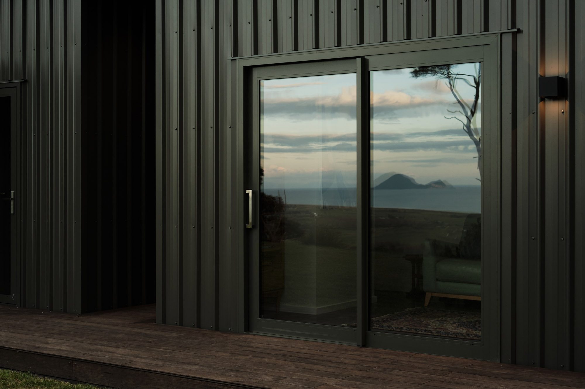 Sunset: Reflections of ocean and whale island on sliding doors