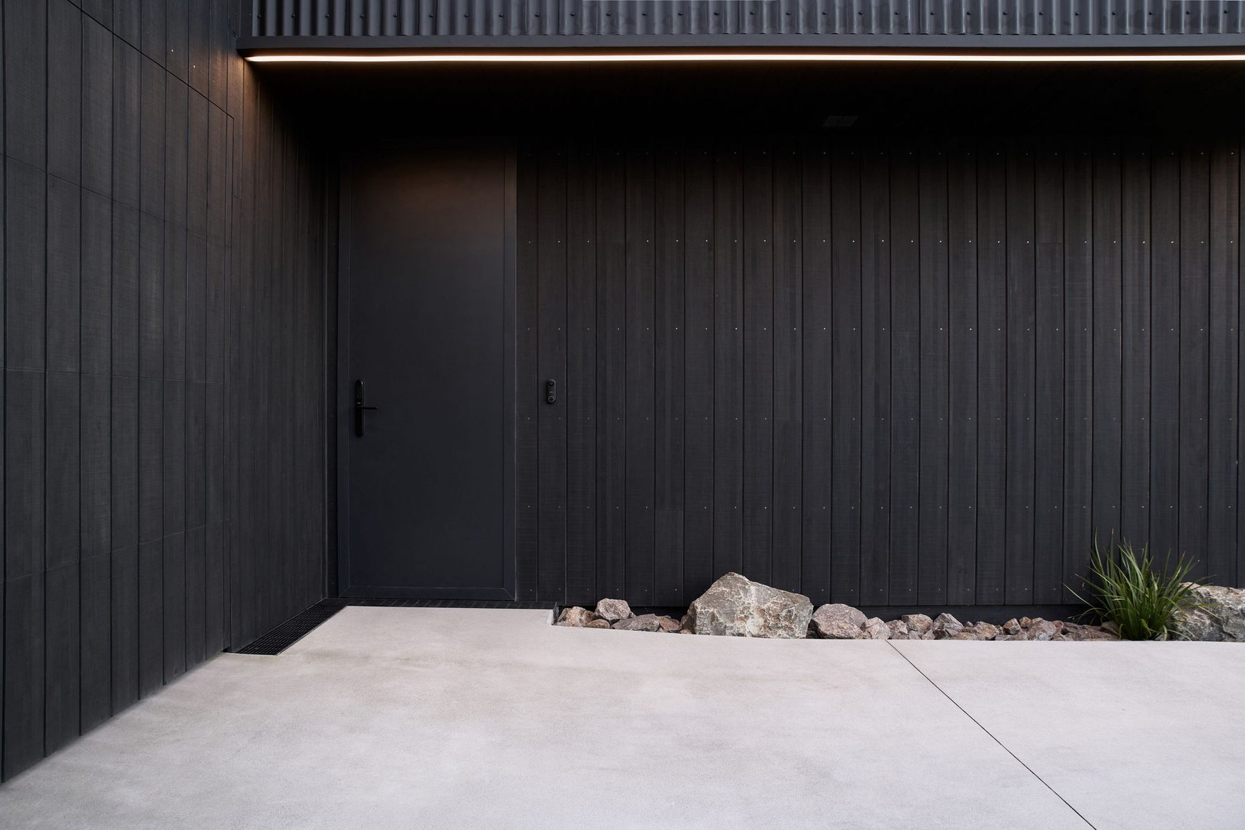 Entrance court: dark cladding, concrete and stone.