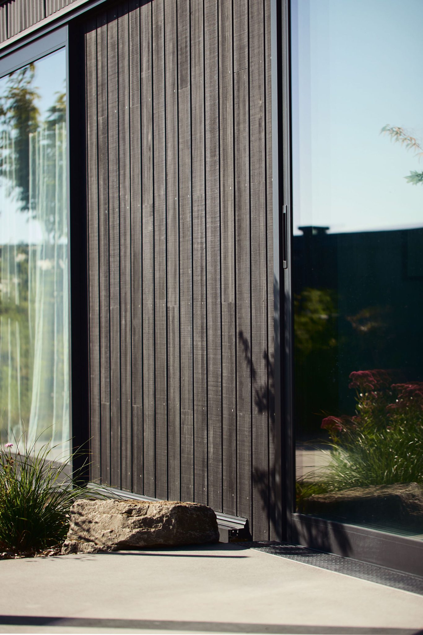 Abodo Vulcan cladding and sliding doors with landscaping reflections