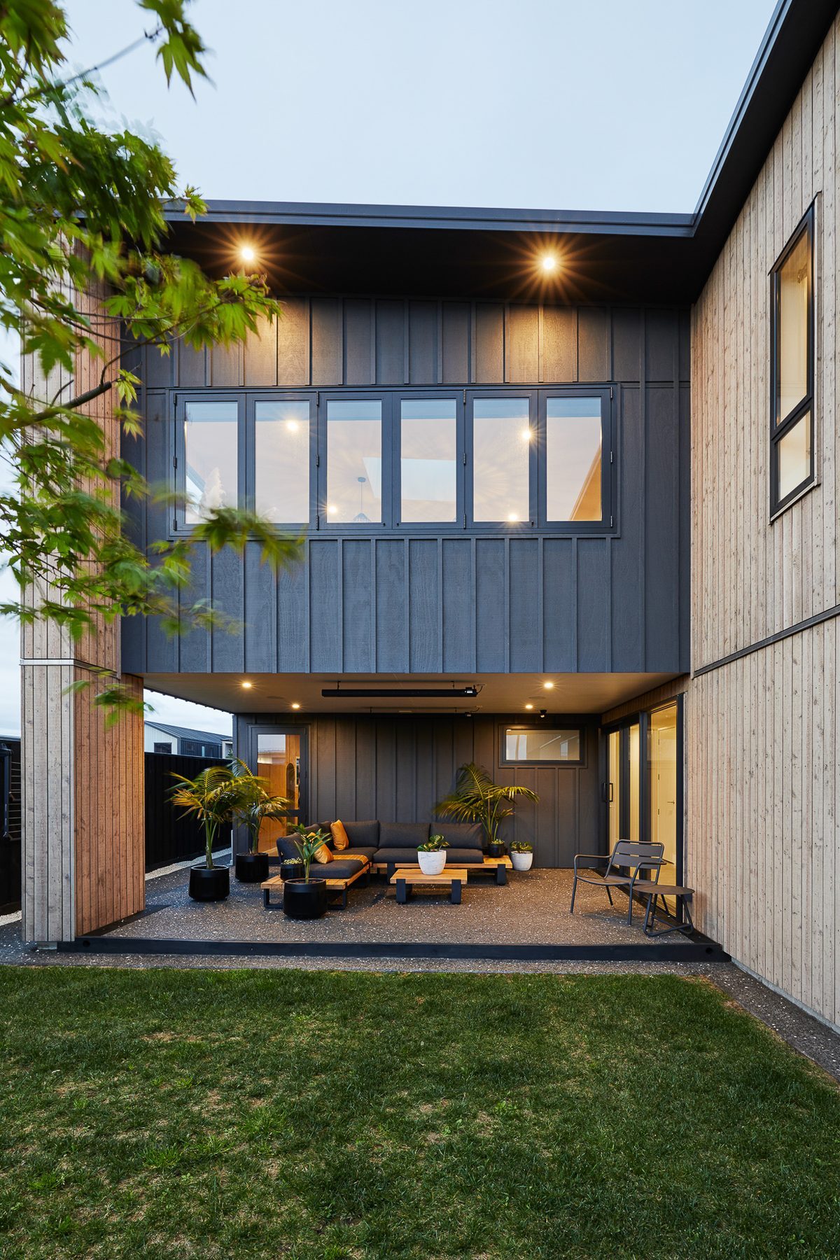 The courtyard at dusk, both storeys glowing.