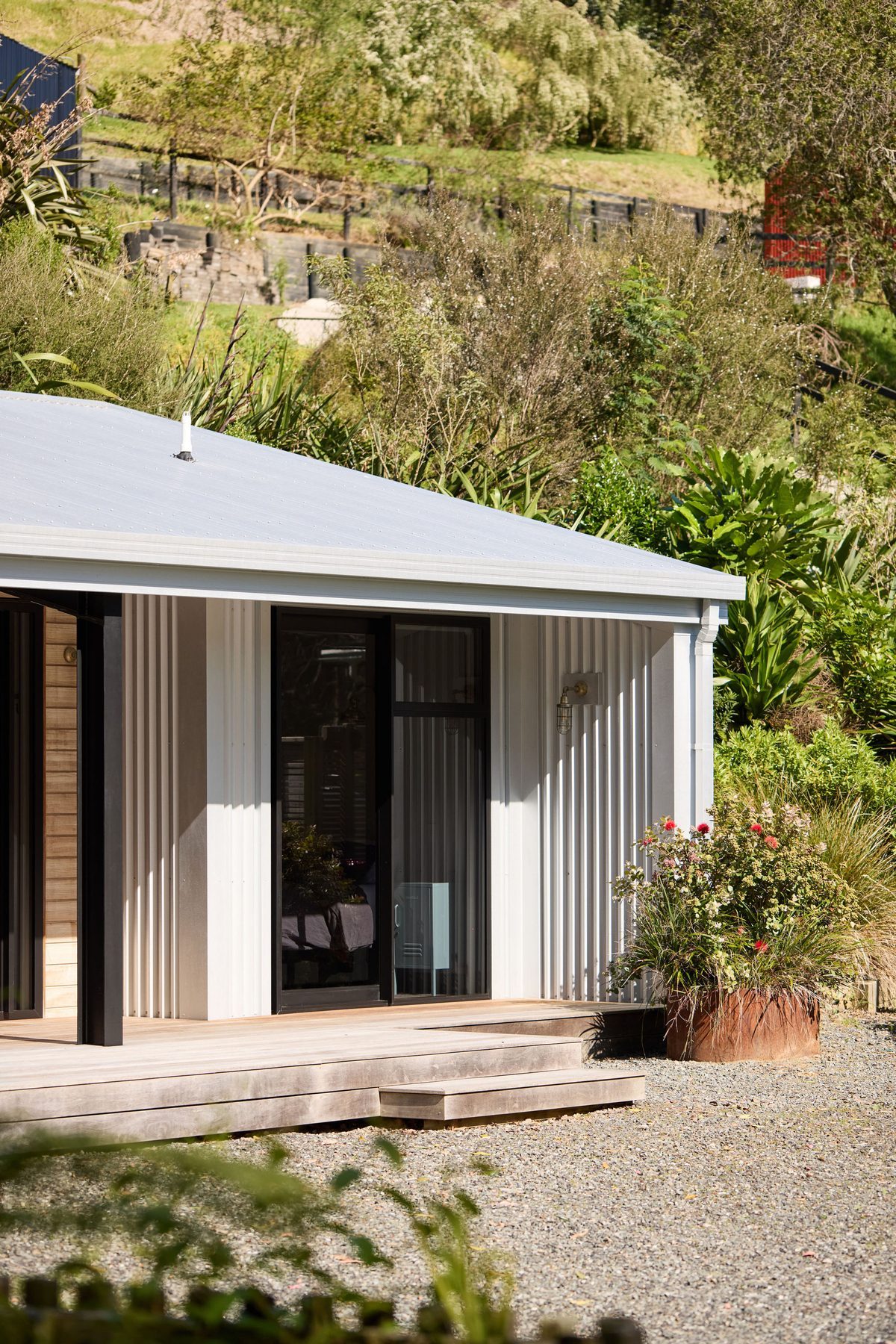 Nestled against the bank, roof rising with the slope.