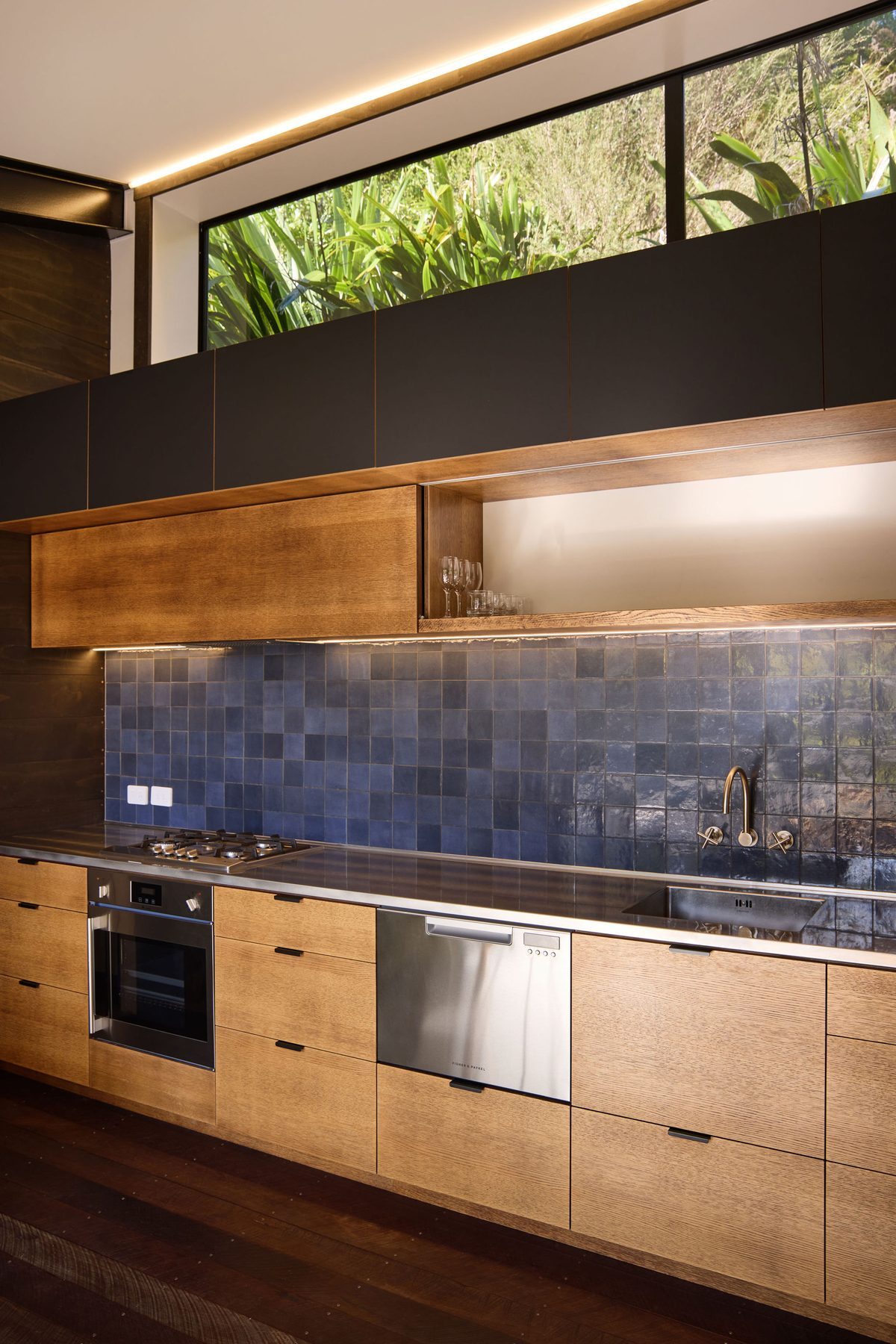 The kitchen in timber and deep blue tile.