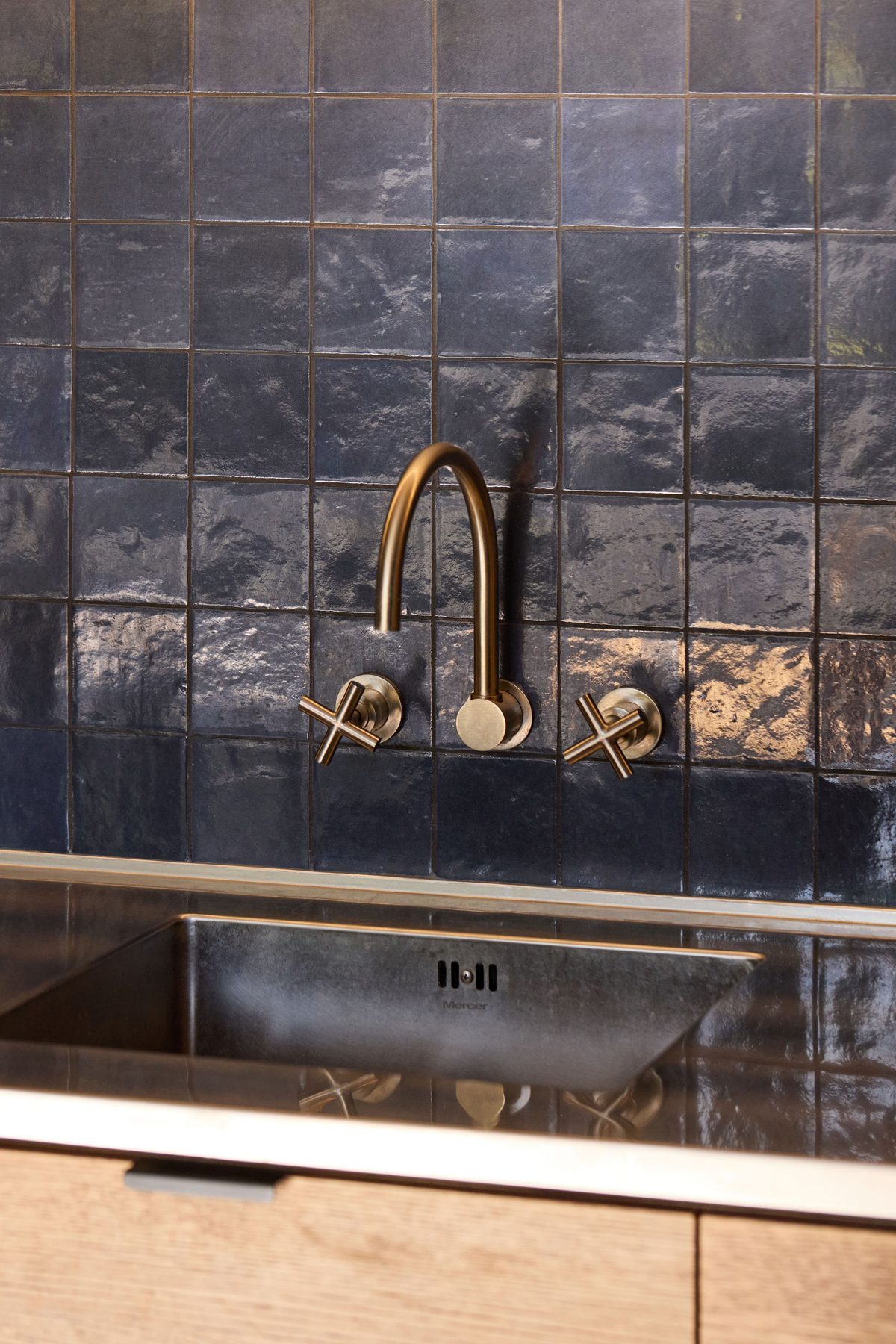 Brass tapware on the blue tile.