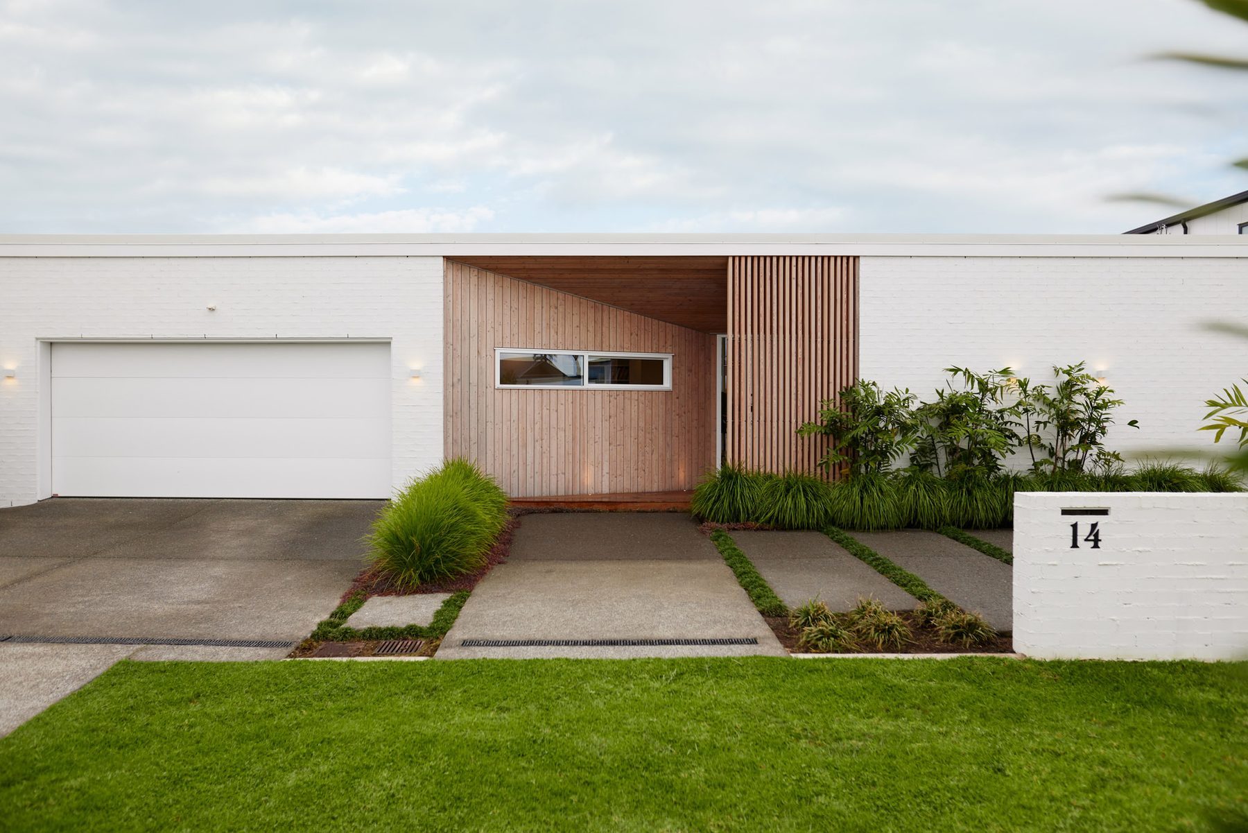 Street elevation: white brick, larch and clean horizontal lines.