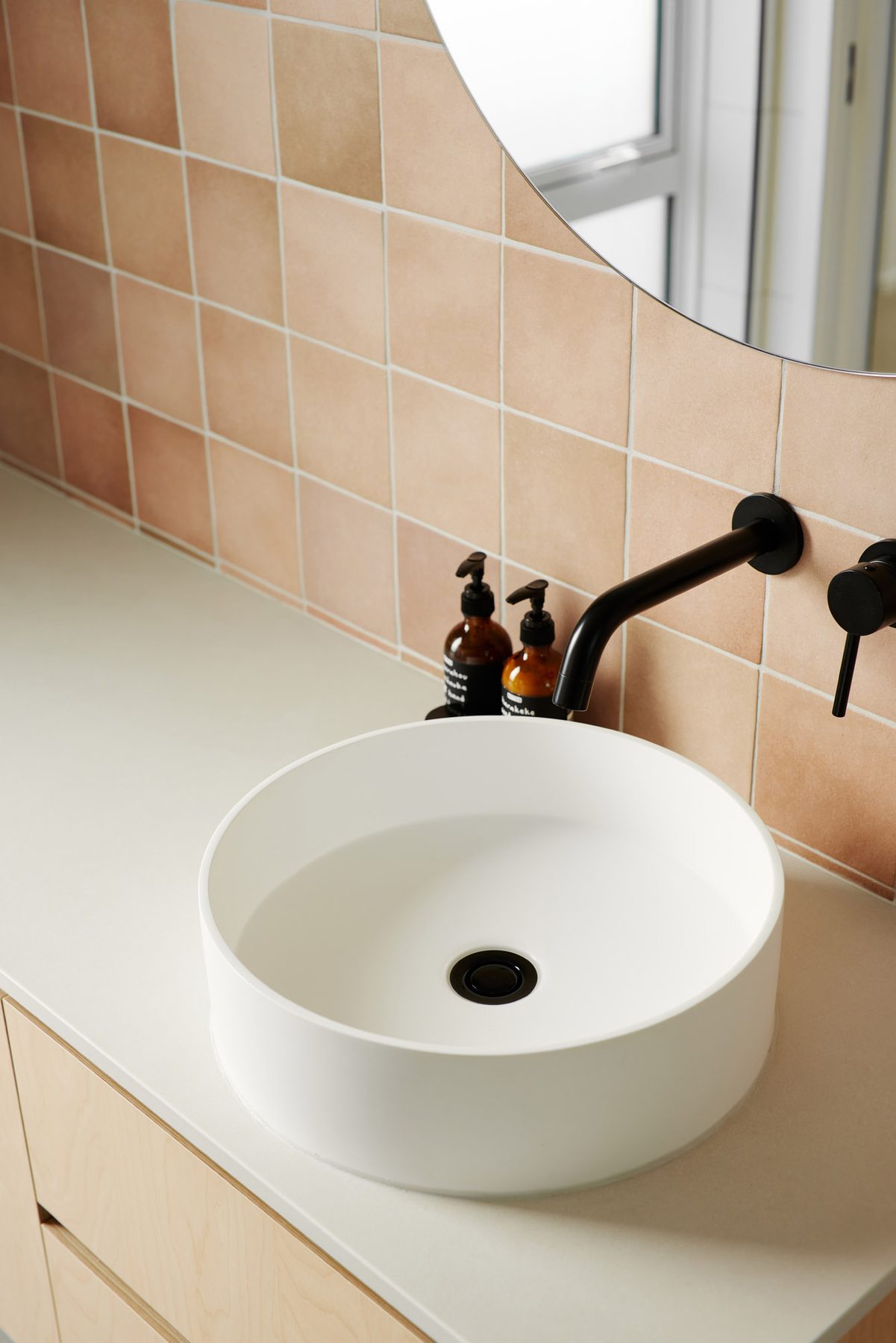 Bathroom in terracotta tile and brass.